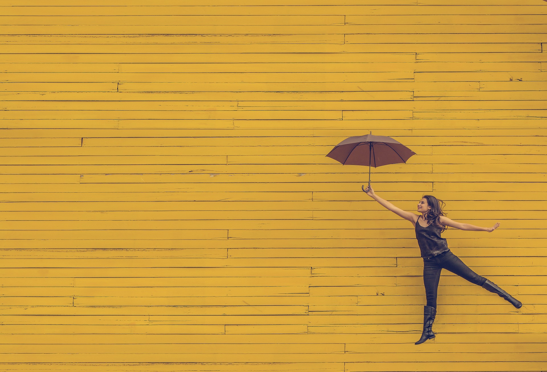 femme heureuse s'envolant avec son parapluie